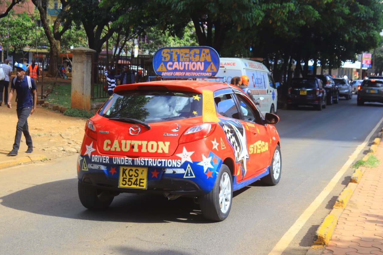 Stega Driving School car on Nairobi road with caution signage